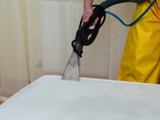 This is a photo of a man steam cleaning a dirty mattress works carried out by Clapham Carpet Cleaning Solutions