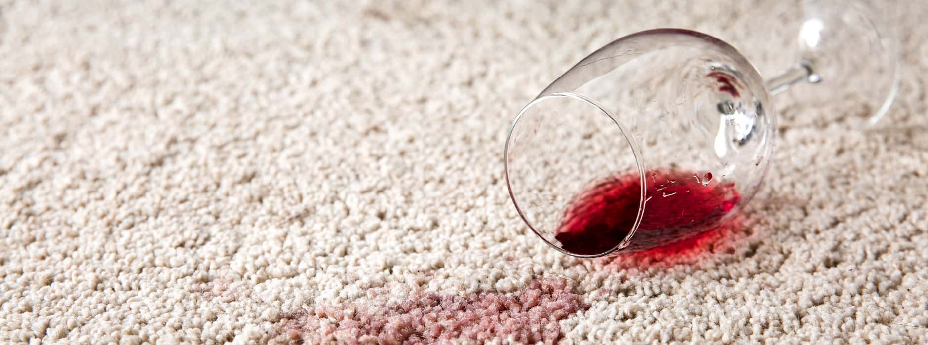 This is a photo of Clapham Carpet Cleaning Solutions red wine which has been spilt on a cream carpet. The glass is on its side